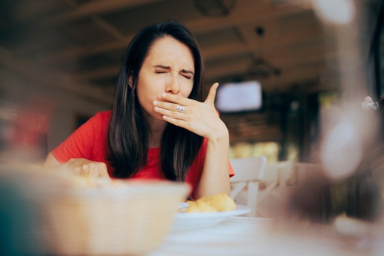 Frau muss nach dem Essen aufstoßen