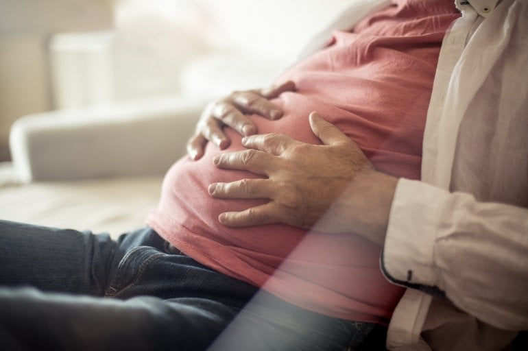 Mann hält seinen Blähbauch