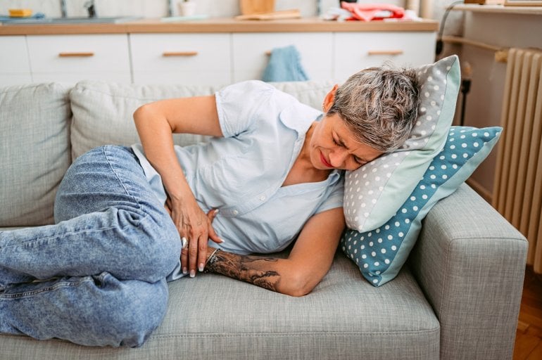 Frau mit Darmverschluss (Ileus) hält ihren Bauch