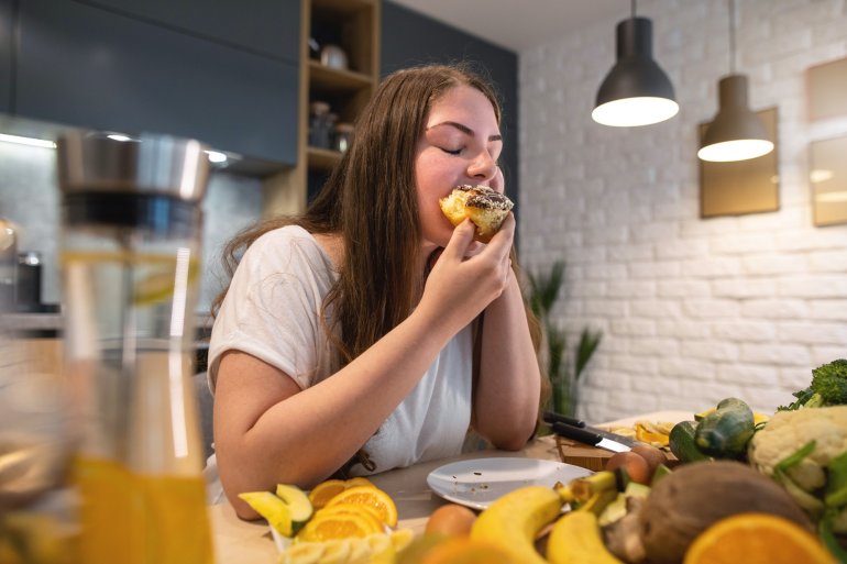 Frau mit Heißhunger isst einen Kuchen