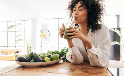 Metabolismus: Frau trinkt grünen Smoothie, Stoffwechsel geginnt.