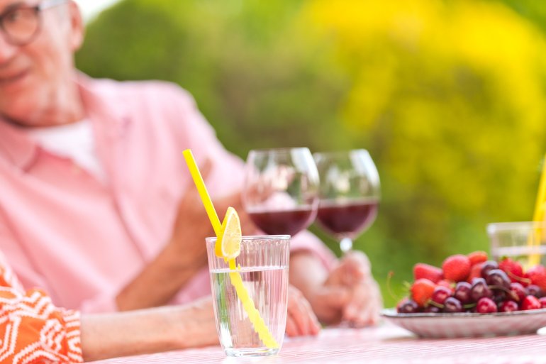 Frau trinkt Wasser nach dem Obst essen