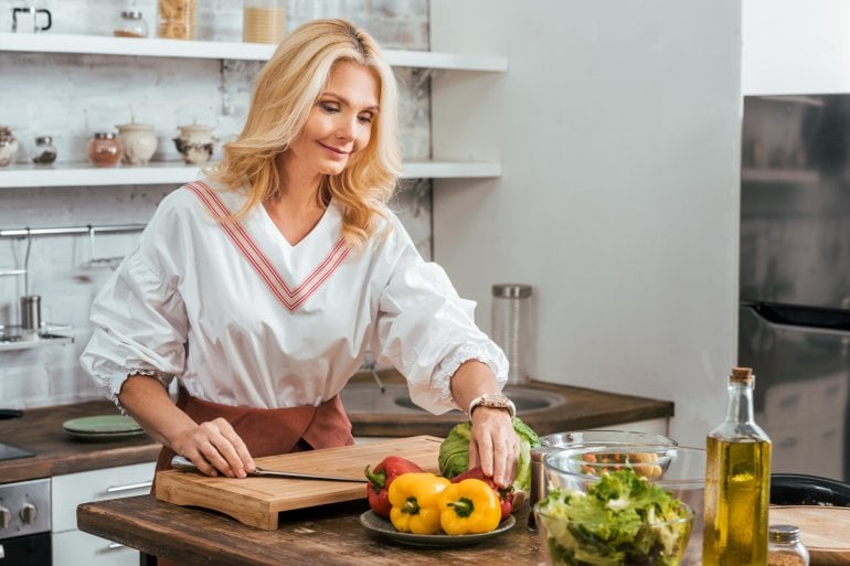 Ältere Frau kocht mit gesunden Zutaten